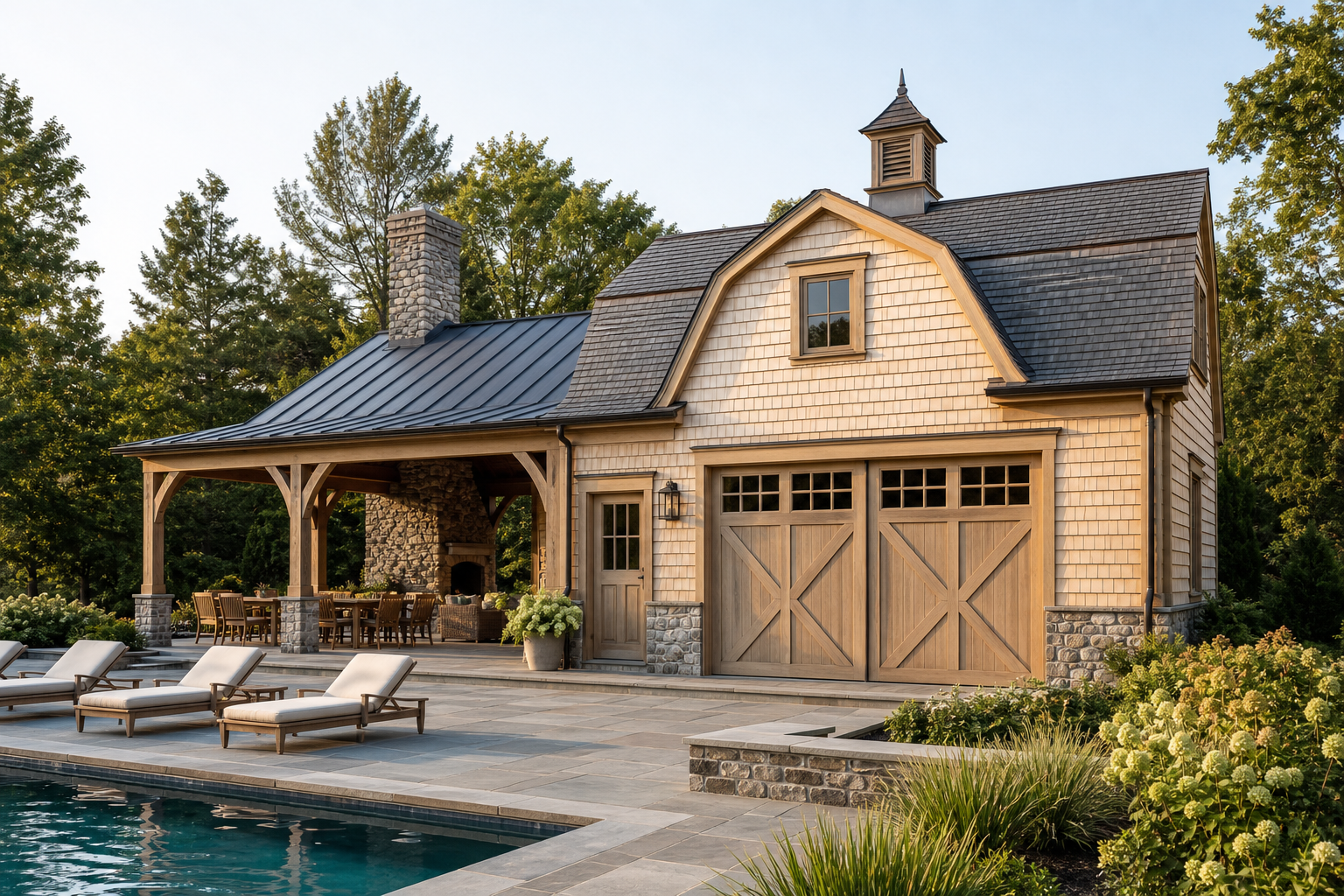 Carriage house pool pavilion with cedar shingles, gambrel roof, fieldstone base, barn doors, and bluestone pool terrace in Greenwich