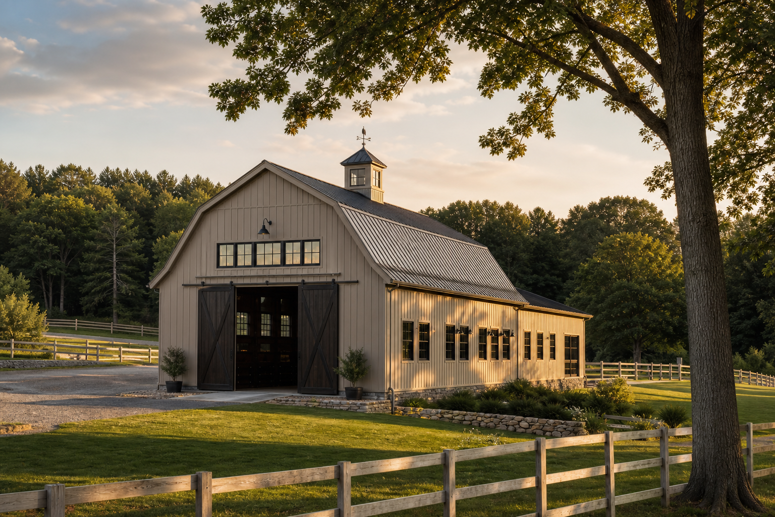 Updated barn with greige board-and-batten siding, black-framed windows, charcoal metal roof, cupola, fieldstone foundation, and rolling green pasture in Darien