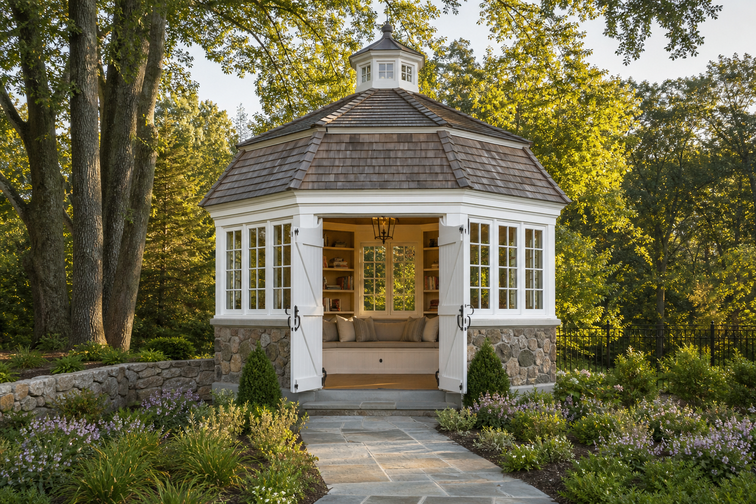 Octagonal carriage-house garden pavilion with gambrel cedar roof, fieldstone walls, white barn doors, and bluestone path through perennial borders in Norwalk
